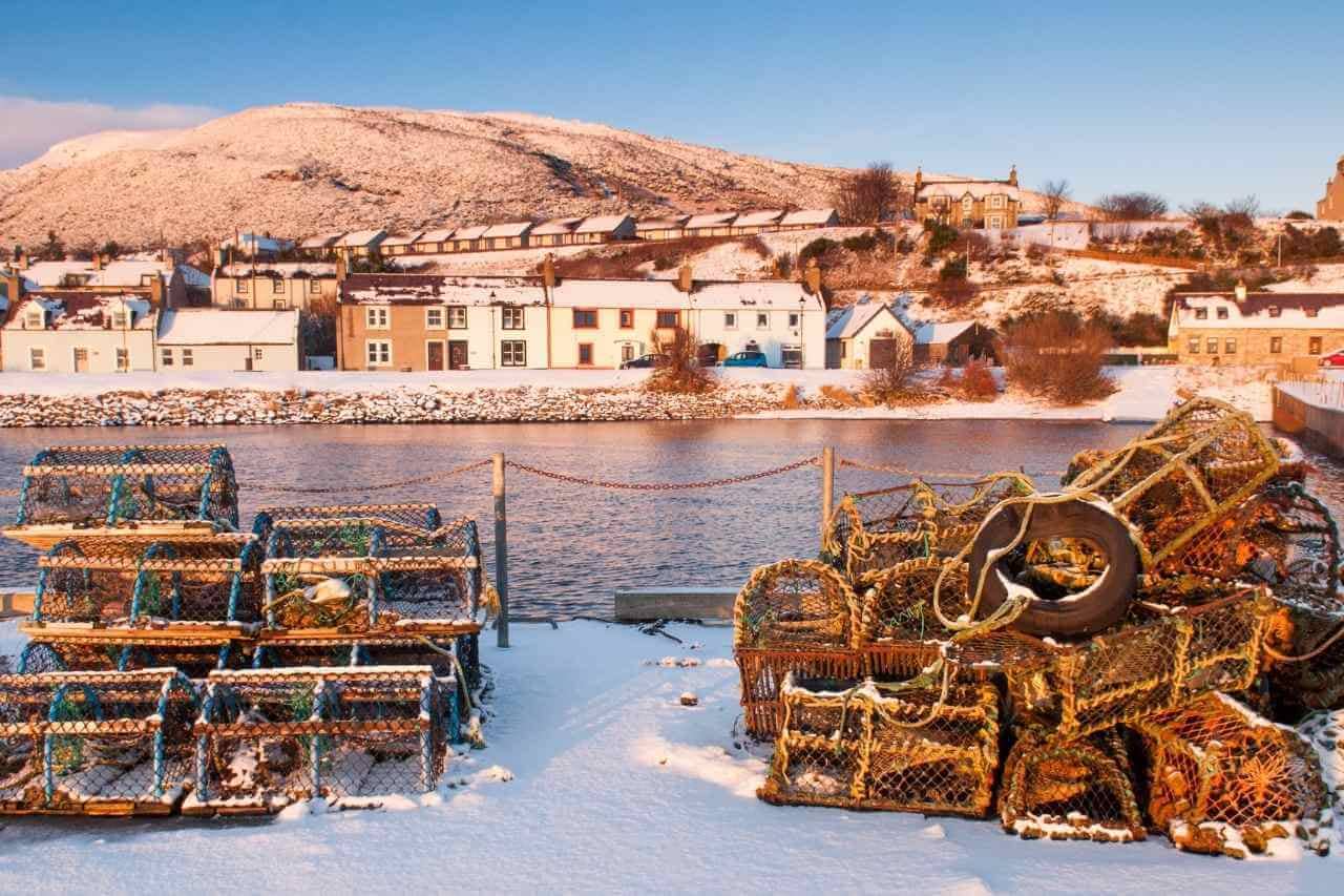 Helmsdale Harbour in the Snow. Lobster Pots stacked.